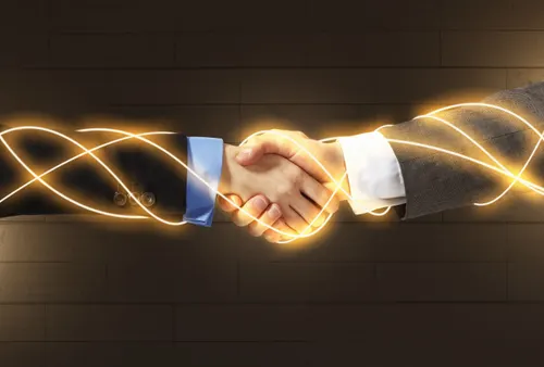 Business partnership handshake with gold light